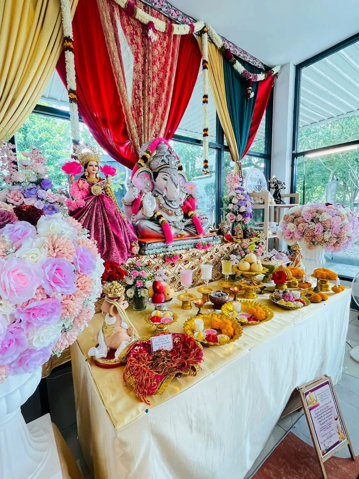 โต๊ะขนมถวายหน้าองค์เทพภายในร้าน