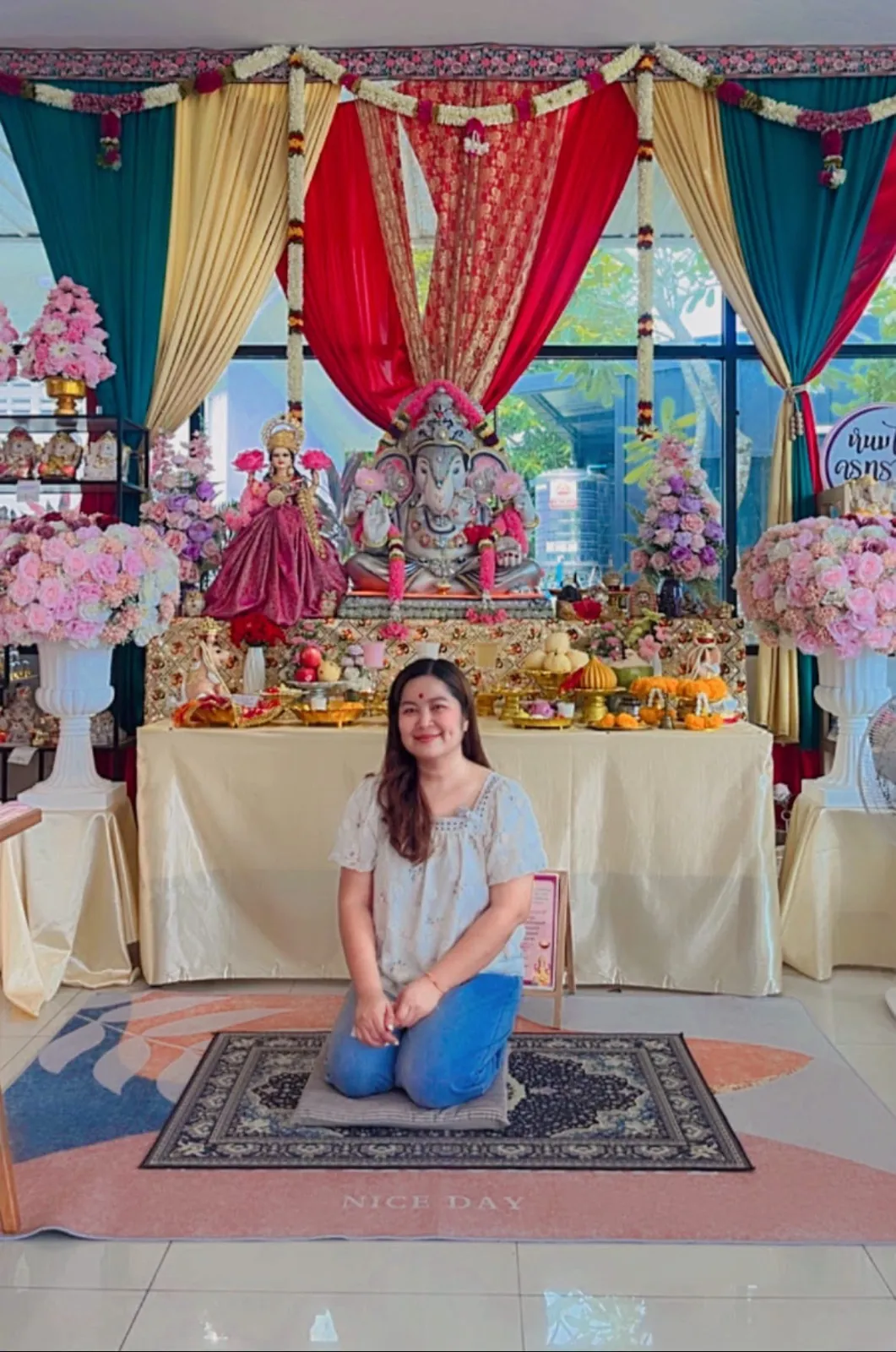 ครูทรายเจ้าของร้านนั่งหน้าห้องบูชาพระพิฆเนศและพระแม่ลักษมีภายในร้าน